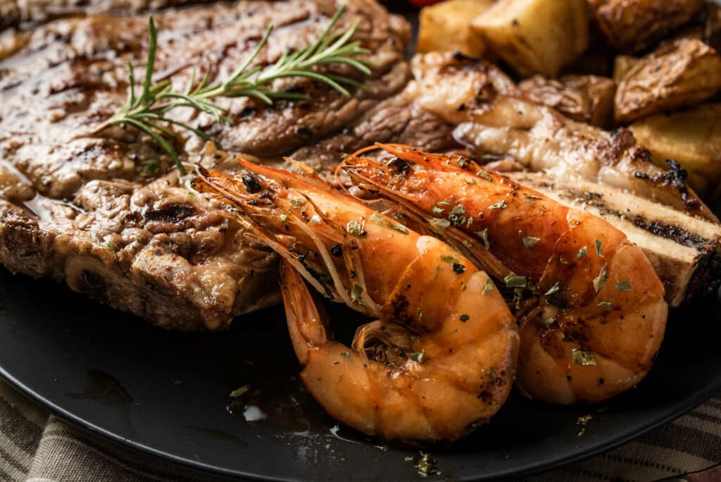 surf and turf, ribeye steak and grilled prawn Surf and turf dinner meal